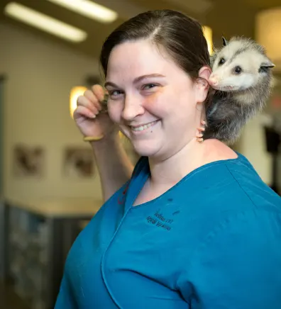 Shelise with an opossum on her shoulder